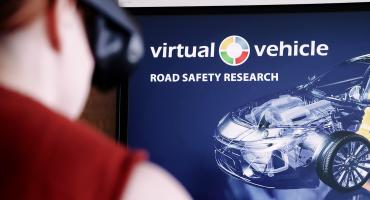 Ein abstrakt dargestelltes Auto und ein Mann von hinten im Vordergrund, der eine VR-Brille anhatt aber unscharf zu sehen ist