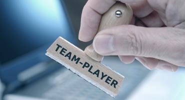 Das Foto zeigt einen Stempel mit der Aufschrift "Teamplayer"